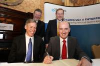 Taoiseach Enda Kenny T.D. (standing right) and Dr. James Reilly T.D, Minister for Health (standing left) witnessing the signing of the deal by Jeff Bolton, Vice President Administration, Mayo Clinic (left) and Keith O’Neill, Director Lifesciences Commercialisation Enterprise Ireland (right).
